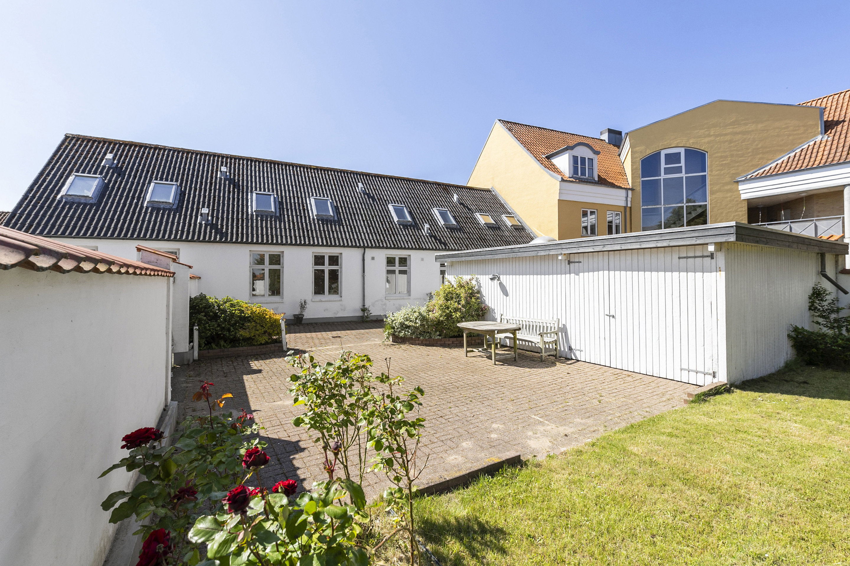 Gårdhave med terrasse, garage og græsplæne