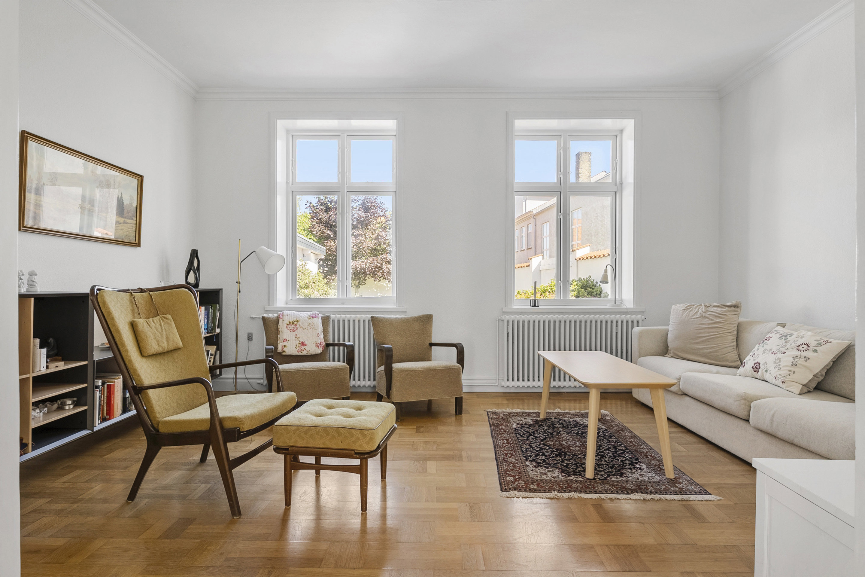 Stue med store vinduer og parketgulv